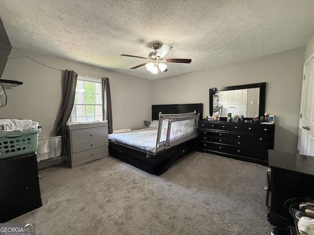 carpeted bedroom with a ceiling fan and a textured ceiling