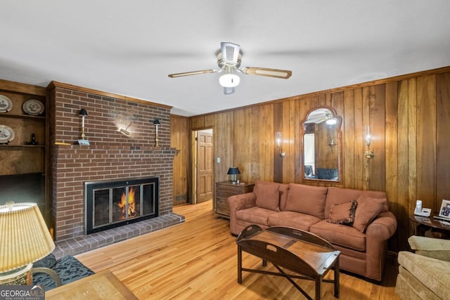 681 Hampton Pl SW, Marietta, GA 30064 - living room with wood walls, a brick fireplace, ceiling fan, and wood finished floors