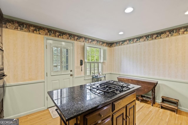 681 Hampton Pl SW, Marietta, GA 30064 - kitchen featuring dark stone counters, wallpapered walls, black gas stovetop, and light wood finished floors