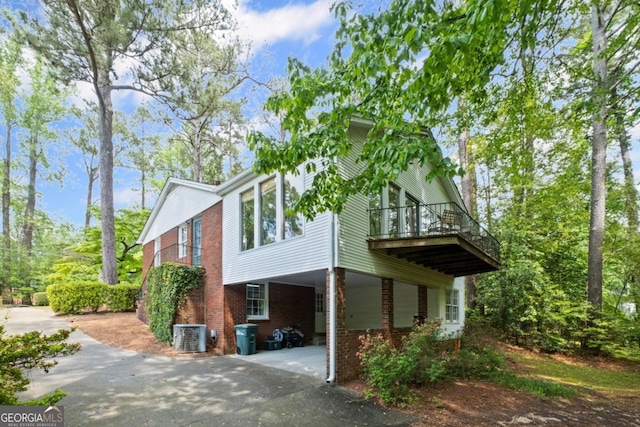 681 Hampton Pl SW, Marietta, GA 30064 - view of property exterior with driveway, central AC unit, a carport, brick siding, and a balcony