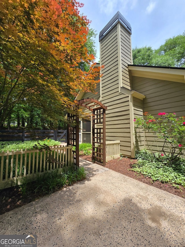5755 Hendrix Rd, Cumming, GA 30040 - view of home's exterior with a chimney and fence
