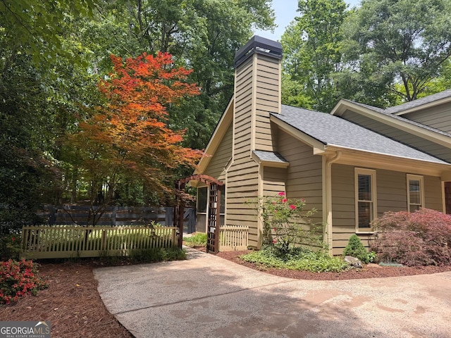 5755 Hendrix Rd, Cumming, GA 30040 - view of side of property with a shingled roof, fence, and a chimney