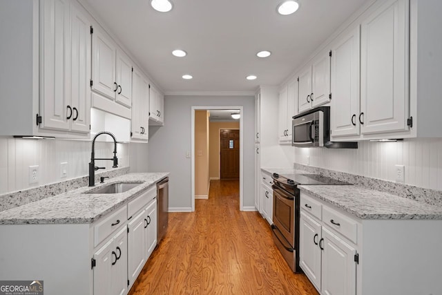 5755 Hendrix Rd, Cumming, GA 30040 - kitchen featuring stainless steel appliances, a sink, light wood finished floors, white cabinets, and recessed lighting