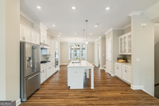 kitchen with a sink, white cabinets, stainless steel appliances, and under cabinet range hood