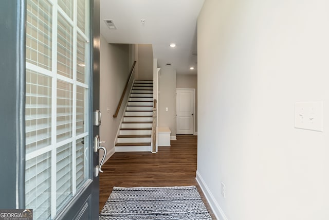 stairway featuring baseboards, recessed lighting, wood finished floors, and visible vents