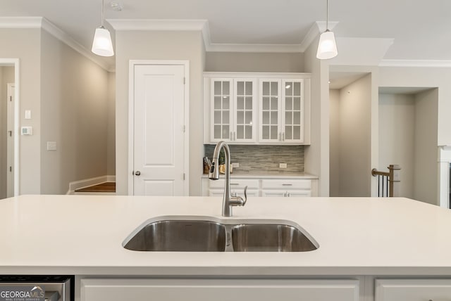kitchen with a sink, light countertops, and decorative light fixtures