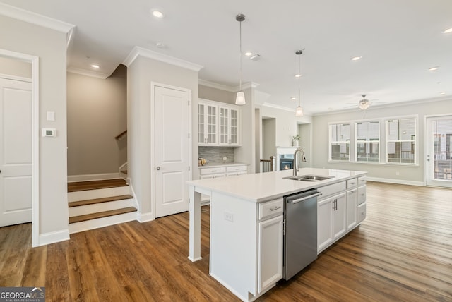 kitchen featuring a sink, dishwasher, white cabinetry, baseboards, and ornamental molding