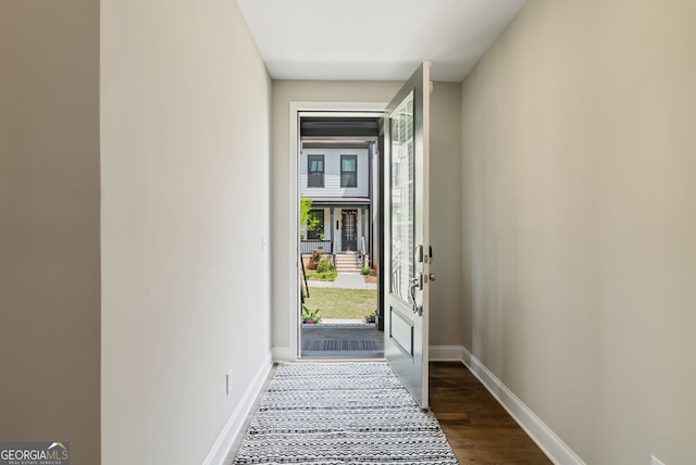 entryway featuring baseboards and dark wood-style floors