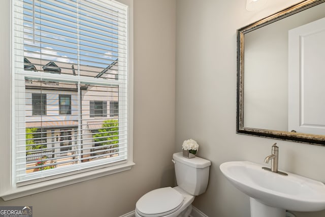 bathroom with baseboards, a sink, and toilet