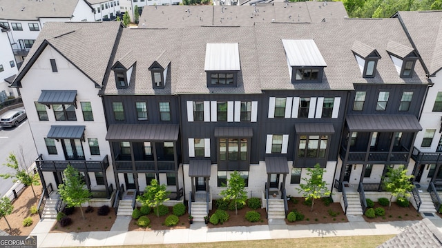 view of front facade with a standing seam roof, a shingled roof, and metal roof