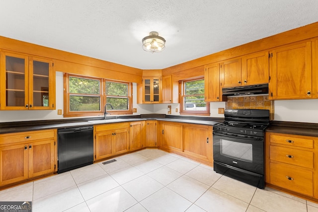 966 Wahoo Creek Rd, Murrayville, GA 30564 - kitchen with brown cabinetry, dark countertops, under cabinet range hood, a sink, and black appliances