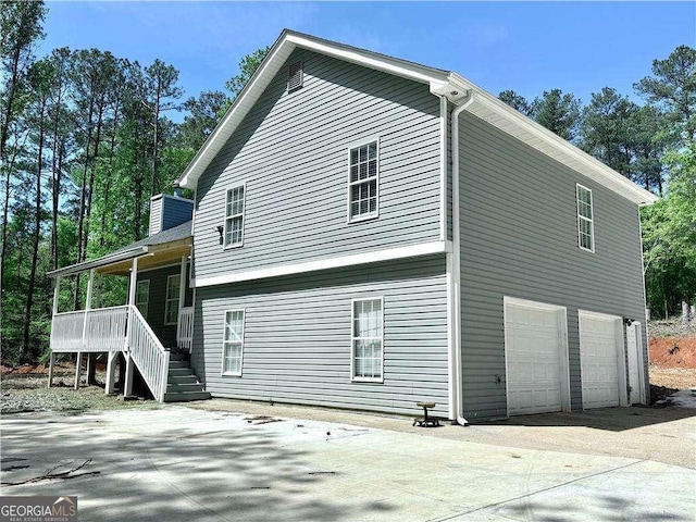 4872 Lewis Rd, Powder Springs, GA 30127 - view of side of property featuring a porch, a chimney, concrete driveway, an attached garage, and stairs