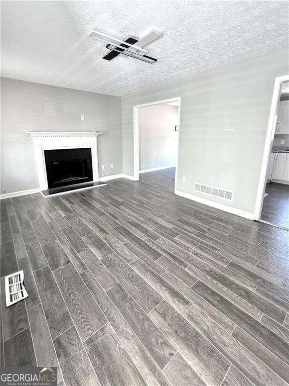 4872 Lewis Rd, Powder Springs, GA 30127 - unfurnished living room featuring baseboards and dark wood-style flooring