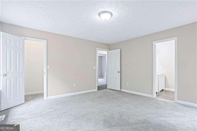 4872 Lewis Rd, Powder Springs, GA 30127 - unfurnished bedroom with carpet flooring, a textured ceiling, baseboards, and connected bathroom