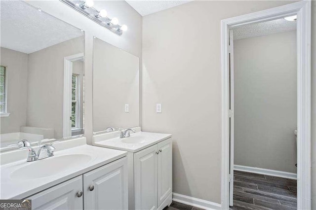 4872 Lewis Rd, Powder Springs, GA 30127 - full bathroom with a textured ceiling, two vanities, and a sink