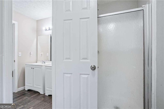 4872 Lewis Rd, Powder Springs, GA 30127 - full bath featuring a textured ceiling, a stall shower, wood finished floors, vanity, and baseboards