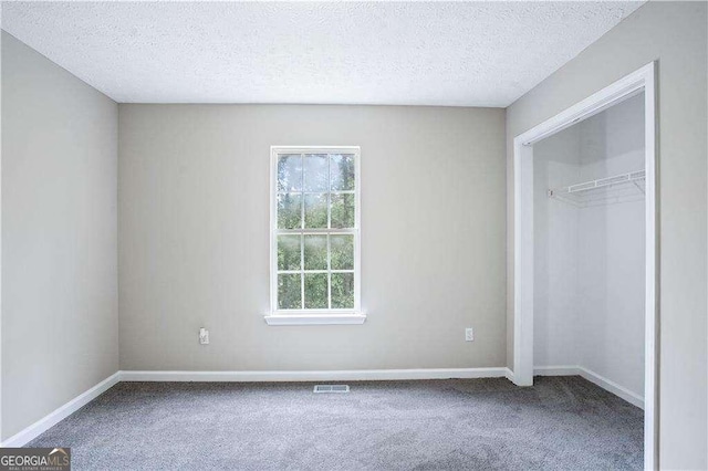 4872 Lewis Rd, Powder Springs, GA 30127 - unfurnished bedroom with a textured ceiling, baseboards, visible vents, and carpet