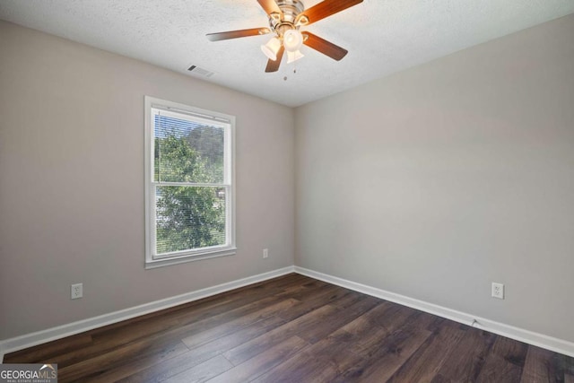 empty room featuring ceiling fan, a textured ceiling, visible vents, baseboards, and dark wood-style floors
