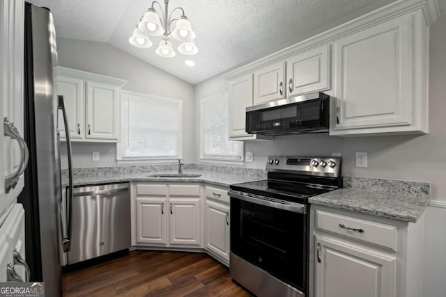 kitchen with a sink, white cabinets, stainless steel appliances, and lofted ceiling