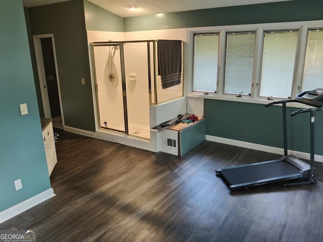 workout room featuring baseboards, dark wood-style flooring, and visible vents