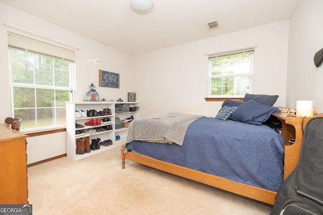carpeted bedroom featuring baseboards and visible vents