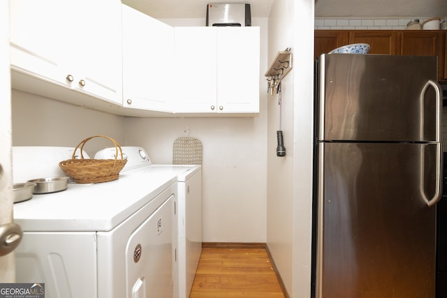 laundry room with light wood finished floors, cabinet space, and washing machine and clothes dryer