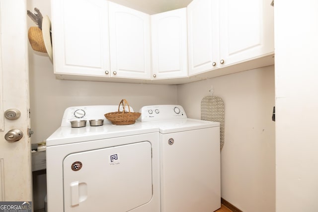 clothes washing area with washer and dryer and cabinet space