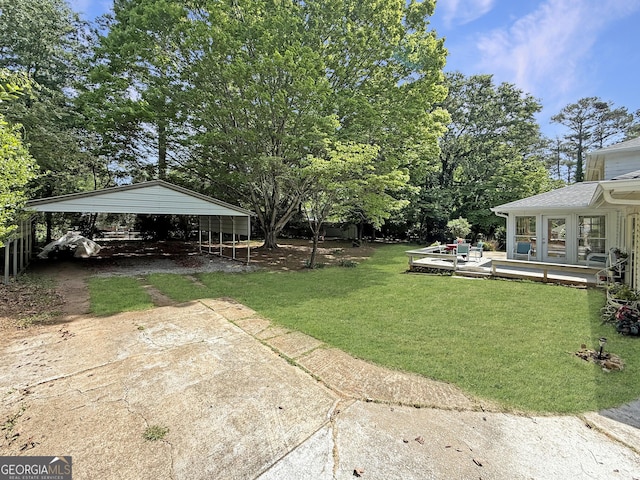 view of yard with a carport and concrete driveway