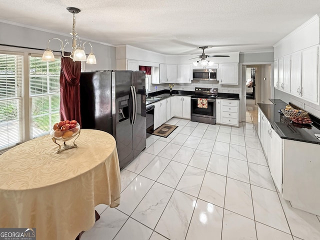 kitchen featuring ornamental molding, white cabinetry, dark countertops, and stainless steel appliances