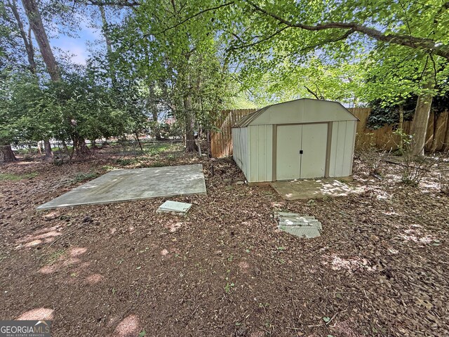 view of yard featuring a fenced backyard, an outdoor structure, and a shed
