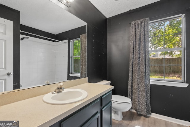 bathroom with walk in shower, wood finished floors, and a wealth of natural light