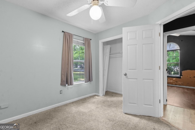 unfurnished bedroom with carpet, baseboards, a ceiling fan, and a closet