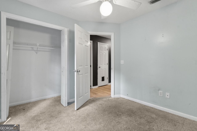 unfurnished bedroom with baseboards, a ceiling fan, carpet, and a closet
