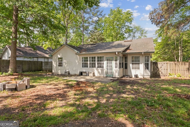 back of property with a patio, a shingled roof, and a fenced backyard