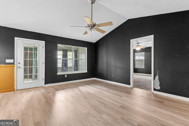 unfurnished room with ceiling fan, wood finished floors, and vaulted ceiling