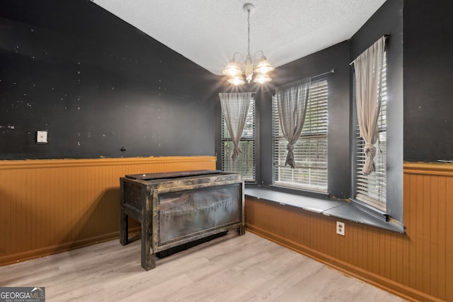 dining room featuring wainscoting, wood finished floors, and a chandelier