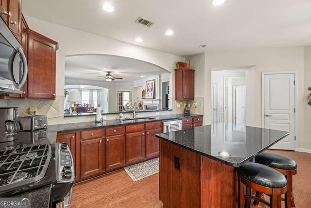 6408 Autumn Crest Ln, Hoschton, GA 30548 - kitchen with a sink, stainless steel appliances, arched walkways, light wood-style flooring, and a ceiling fan