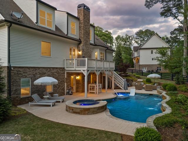 15626 Birmingham Hwy, Milton, GA 30004 - back of house at dusk featuring stairs, a patio area, a pool with connected hot tub, and a chimney