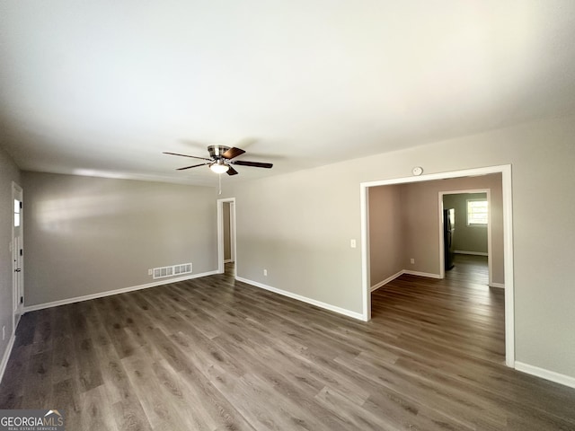 spare room featuring baseboards, a ceiling fan, wood finished floors, and visible vents