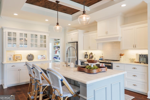 kitchen featuring premium range hood, white cabinets, a tray ceiling, and stainless steel appliances