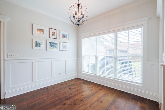 unfurnished dining area featuring an inviting chandelier, ornamental molding, a healthy amount of sunlight, and a wainscoted wall