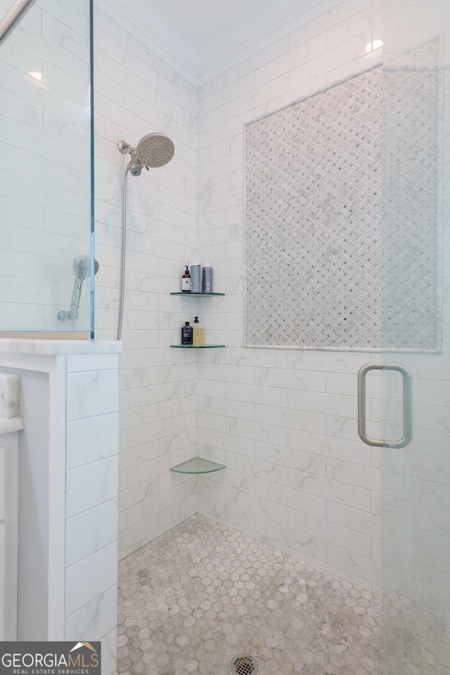 full bathroom with ornamental molding and tiled shower