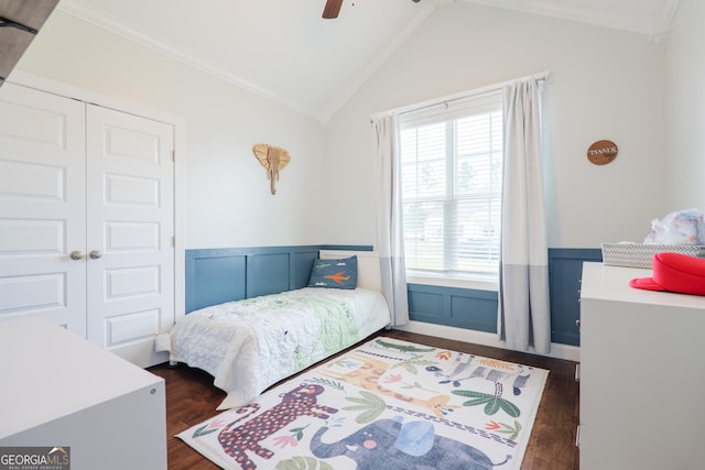 bedroom featuring dark wood finished floors, wainscoting, and multiple windows