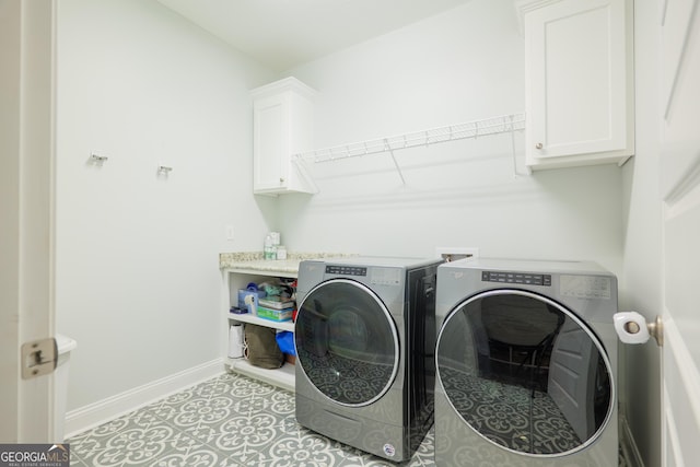 washroom with baseboards, light tile patterned flooring, cabinet space, and washer and dryer