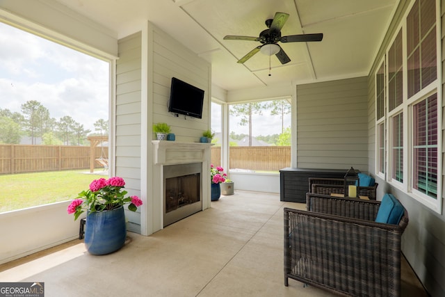 view of patio with an outdoor fireplace, a ceiling fan, and a fenced backyard