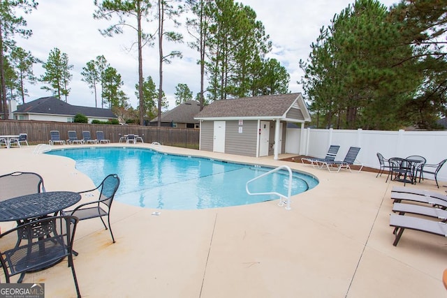 community pool featuring a patio and fence