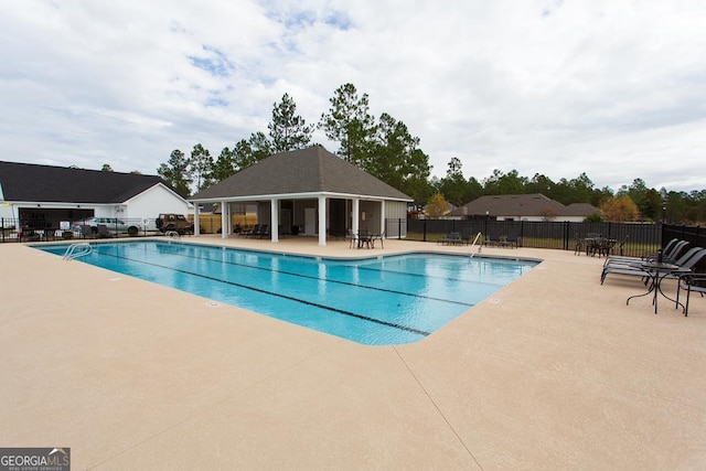 pool with fence and a patio area