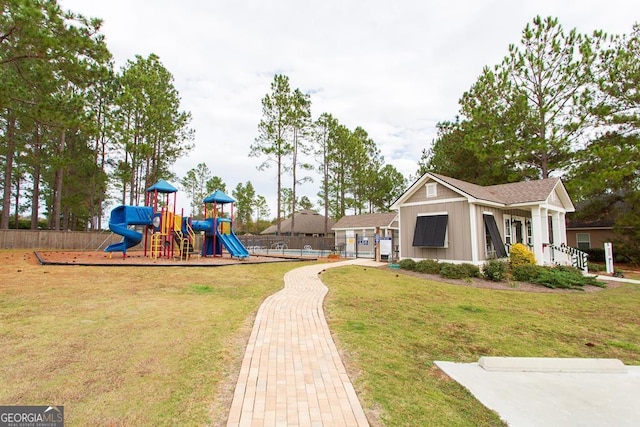 view of playground with a lawn and fence