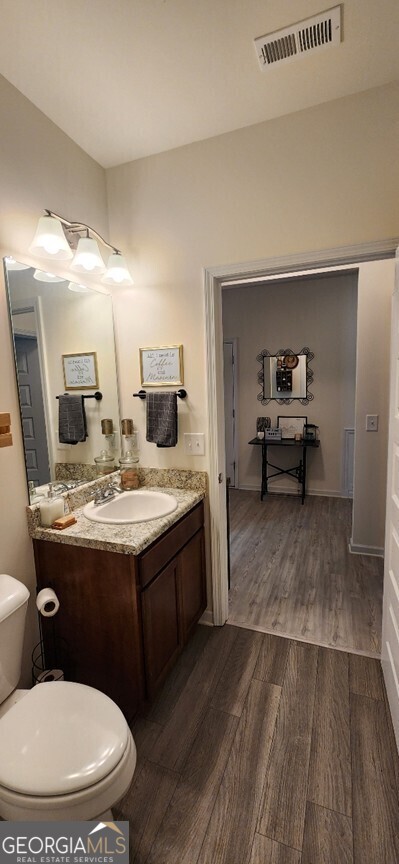 77 Willowrun Dr SW, Rome, GA 30165 - half bathroom with vanity, toilet, wood finished floors, and visible vents