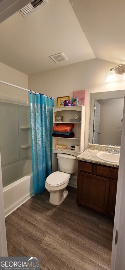 77 Willowrun Dr SW, Rome, GA 30165 - bathroom featuring vanity, toilet, shower / bathtub combination with curtain, wood finished floors, and visible vents